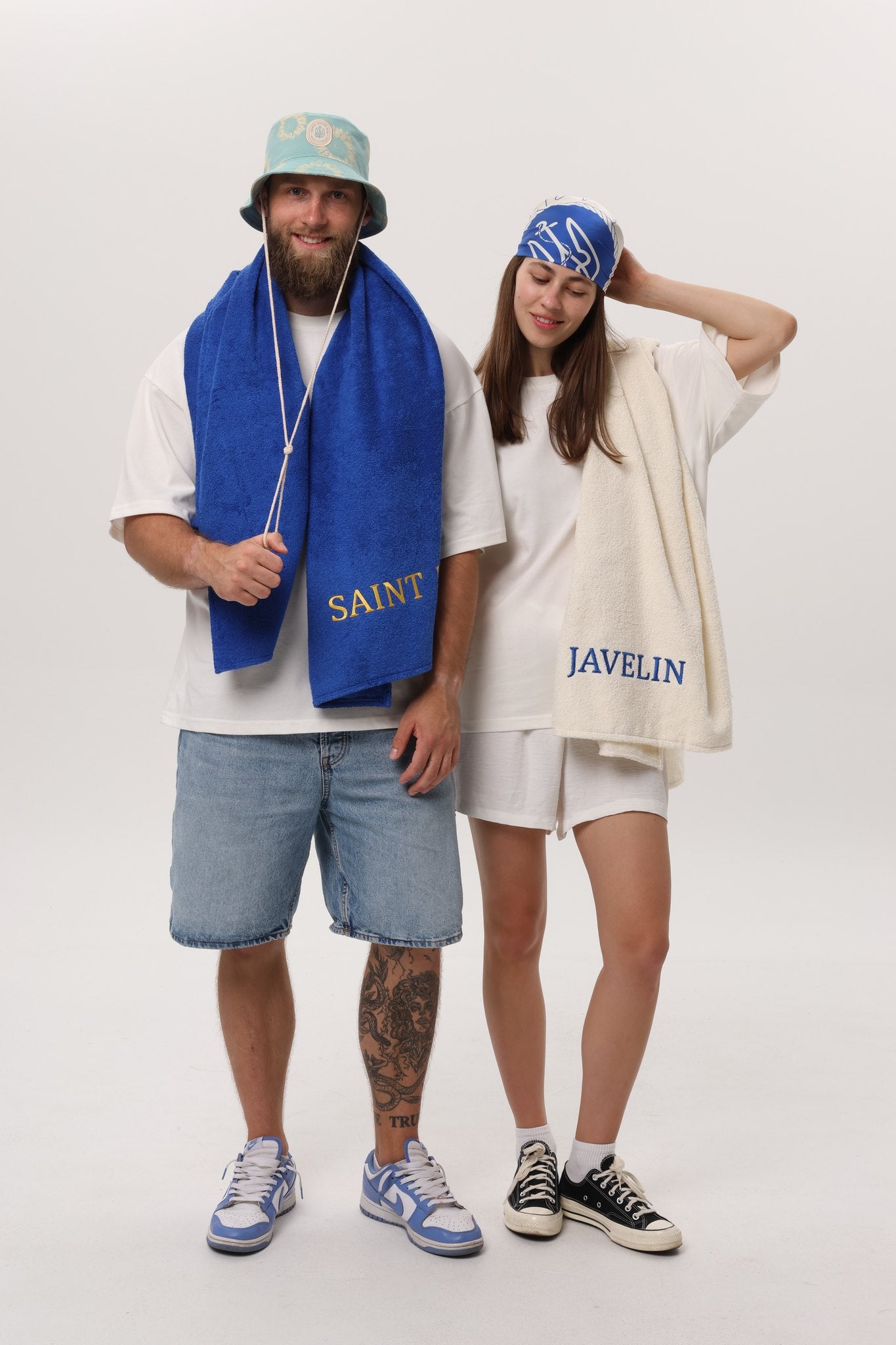 Two models wearing Saint Javelin beach towels, royal blue and bone